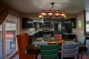 a kitchen with a dining table and a chandelier at Modern Desert Delight! 4- bedrooms, pool, gameroom in Lake Havasu City