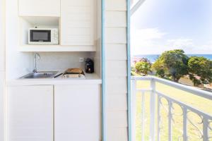 a kitchen with a view of the ocean from a balcony at Résidence Pierre & Vacances Premium Les Tamarins in Sainte-Anne