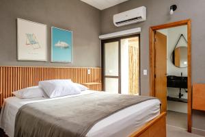 a bedroom with a large bed and a window at JQY Beach Flats - 950m da Praia - Garagem subterrânea - Estação de carregamento para veículos elétricos in Juquei