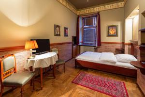 Hotel Continental في بلزن: غرفة نوم بسرير وطاولة ومكتب