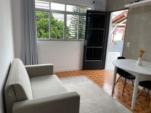 a living room with a chair and a table at Residencial Sullivan - Florianópolis - Loft 01 in Florianópolis