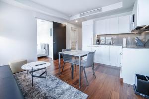 a kitchen and dining room with a table and chairs at Award-Winning One-Bedroom Suite at Telus Sky in Calgary