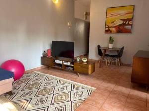 a living room with a flat screen tv and a table at A cozy one-bedroom in Heron, Djibouti in La Plaine