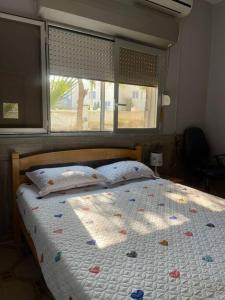 a bedroom with a bed with a window and a bedspread at A cozy one-bedroom in Heron, Djibouti in La Plaine