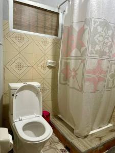 a bathroom with a toilet and a shower curtain at A cozy one-bedroom in Heron, Djibouti in La Plaine