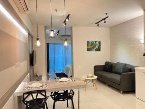 吉隆坡的住宿－Mercu Summer Suites KLCC By Sweet Home，客厅配有桌子和沙发