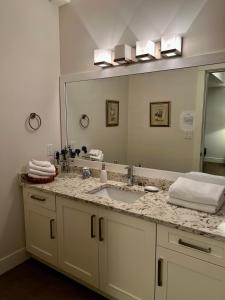baño con lavabo y espejo grande en Ocean Melody Vacation Rooms, en Nanaimo