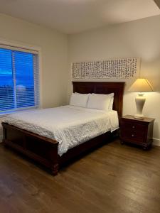 a bedroom with a bed and a lamp and a window at Ocean Melody Vacation Rooms in Nanaimo