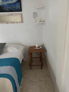 1 dormitorio con 1 cama y mesita de noche con mesa en Cuarto chingui, en Isla Holbox
