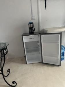 - un réfrigérateur blanc à côté d'une table et d'une cafetière dans l'établissement Cuarto chingui, à Holbox
