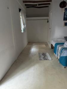 een witte kamer met een bed en een tapijt bij Cuarto chingui in Holbox Island