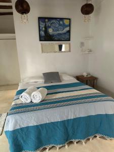 una camera da letto con un letto e due asciugamani di Cuarto chingui a Isola Holbox