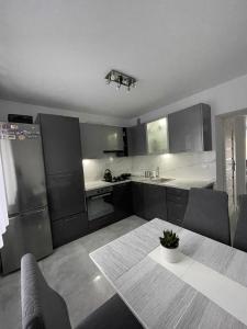 a kitchen with stainless steel appliances and a table at Apartament pod Łebą in Charbrowo
