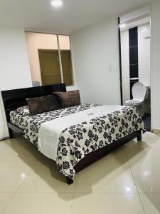 sypialnia z łóżkiem z czarno-białą kołdrą w obiekcie Hotel Colonial El Bosque Dorado w mieście Tunja
