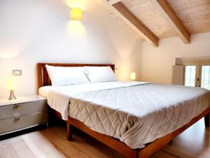 een slaapkamer met een groot bed met witte lakens bij Villa Angelina Garda in Cavalcaselle