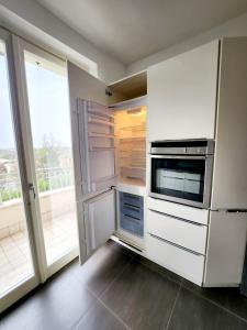 een keuken met witte kasten en apparaten en een raam bij Villa Angelina Garda in Cavalcaselle