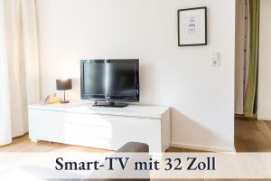 un televisor sentado en la parte superior de una cómoda blanca en Relax-Apartment-Two Ravensburg, en Ravensburg