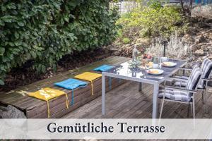 una mesa y sillas en una terraza de madera en Relax-Apartment-Two Ravensburg, en Ravensburg