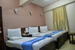 two beds in a room with two beds sidx sidx sidx at Abo Elwafa Hotel in Suwhaj