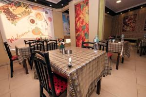 un comedor con mesas y sillas en un restaurante en Abo Elwafa Hotel, en Sūhāj