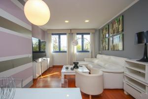 Una sala de estar con un sofá blanco y una mesa. en Luxury apt in Plaza de España - FREE parking, en Sevilla