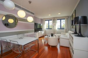 Una sala de estar con una mesa y sillas blancas. en Luxury apt in Plaza de España - FREE parking, en Sevilla