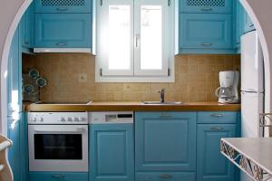 a kitchen with blue cabinets and a sink at Dolce Vita Waterfront Villa, Logaras, Paros in Kampos Paros