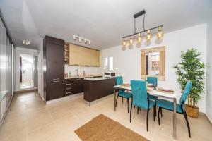 a kitchen and dining room with a table and chairs at Luxury Apartment Chalana in Playa Honda