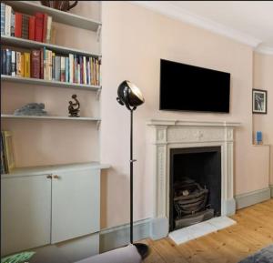sala de estar con TV y chimenea en Holborn Home: Find Iconic London, en Londres