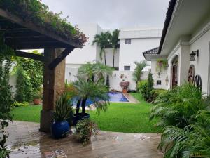 Casa en Samborondón في غواياكيل: ساحة منزل بها مسبح ونباتات