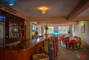 a bar in a restaurant with tables and chairs at Lakou Breda in Cap-Haïtien