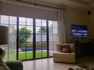 Casa en Samborondón في غواياكيل: غرفة معيشة مع باب زجاجي منزلق كبير