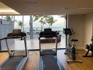 a gym with cardio machines and a view of the ocean at Beautiful Accommodation - #Unity Flats Cabo Branco in João Pessoa