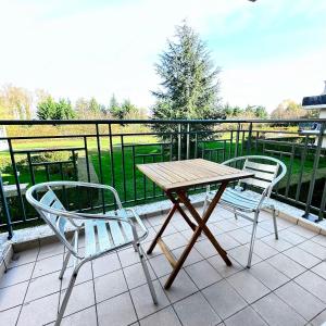 - Balcón con mesa de madera y 2 sillas en Beautiful apartment * parking* Disneyland 10 min en Montévrain