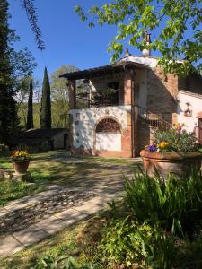 una casa con un edificio in pietra e un balcone di Il Bosco del Lebbio a Montaione