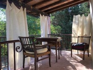 a patio with two chairs and a table on a porch at Il Bosco del Lebbio in Montaione