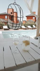 una mesa con dos copas de vino y un orbe en Punta Piedra cabañas & suites en Los Reartes