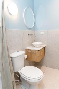 a bathroom with a toilet and a sink and a mirror at CASA MARU - La Celeste in Vicente López