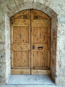 una grande porta in legno in un muro di pietra di Il Bosco del Lebbio a Montaione