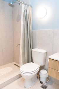 a bathroom with a white toilet and a shower at CASA MARU - La Celeste in Vicente López