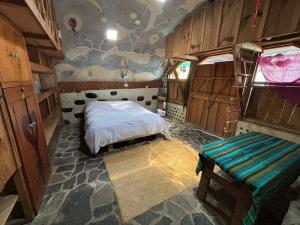 a bedroom with a bed in a room with wooden walls at Earthship 3 levels apartment starboard cabin with lake view in San Marcos La Laguna