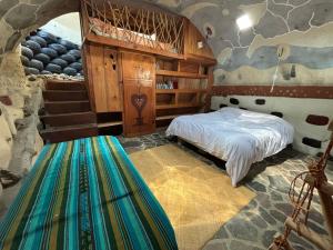 a bedroom with a bed in a room with a stone wall at Earthship 3 levels apartment starboard cabin with lake view in San Marcos La Laguna