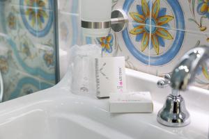 a bathroom sink with a bottle of toothpaste on it at REDDIMUS Guest House in Naples