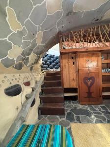 a room with a staircase and a stone wall at Earthship 3 levels apartment starboard cabin with lake view in San Marcos La Laguna