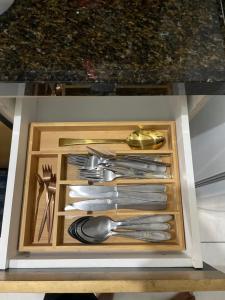 a drawer full of silver utensils in a cabinet at Apart Governador Valadares in Governador Valadares