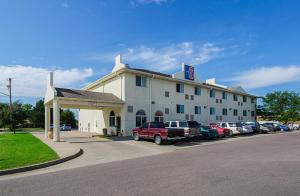 a hotel with cars parked in a parking lot at Motel 6-Fort Lupton, CO in Fort Lupton