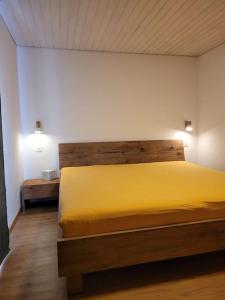 Ferienapartment Fieschertal في Fieschertal: غرفة نوم بسرير اصفر كبير بها مصباحين