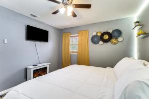 een slaapkamer met een wit bed en een flatscreen-tv bij Inviting Savannah Home with Yard 3 Mi to Downtown! in Savannah