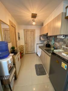 una pequeña cocina con nevera y fregadero en Cozy and Convenient studio unit @ Inspiria condominium, en Davao City
