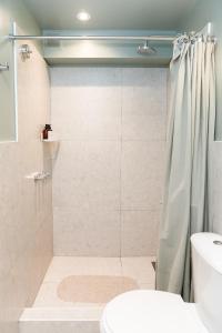 y baño con ducha, aseo y lavamanos. en CASA MARU - La Verde en Vicente López